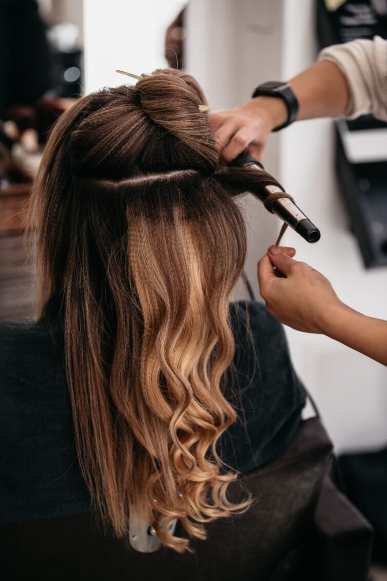 Female customer having her hair styled by a professional hairdresser in a modern salon setting